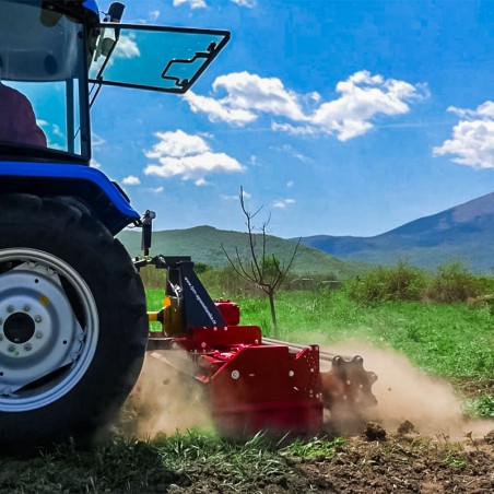 Herses rotatives monté sur tracteur agricole en action - Vue de profil